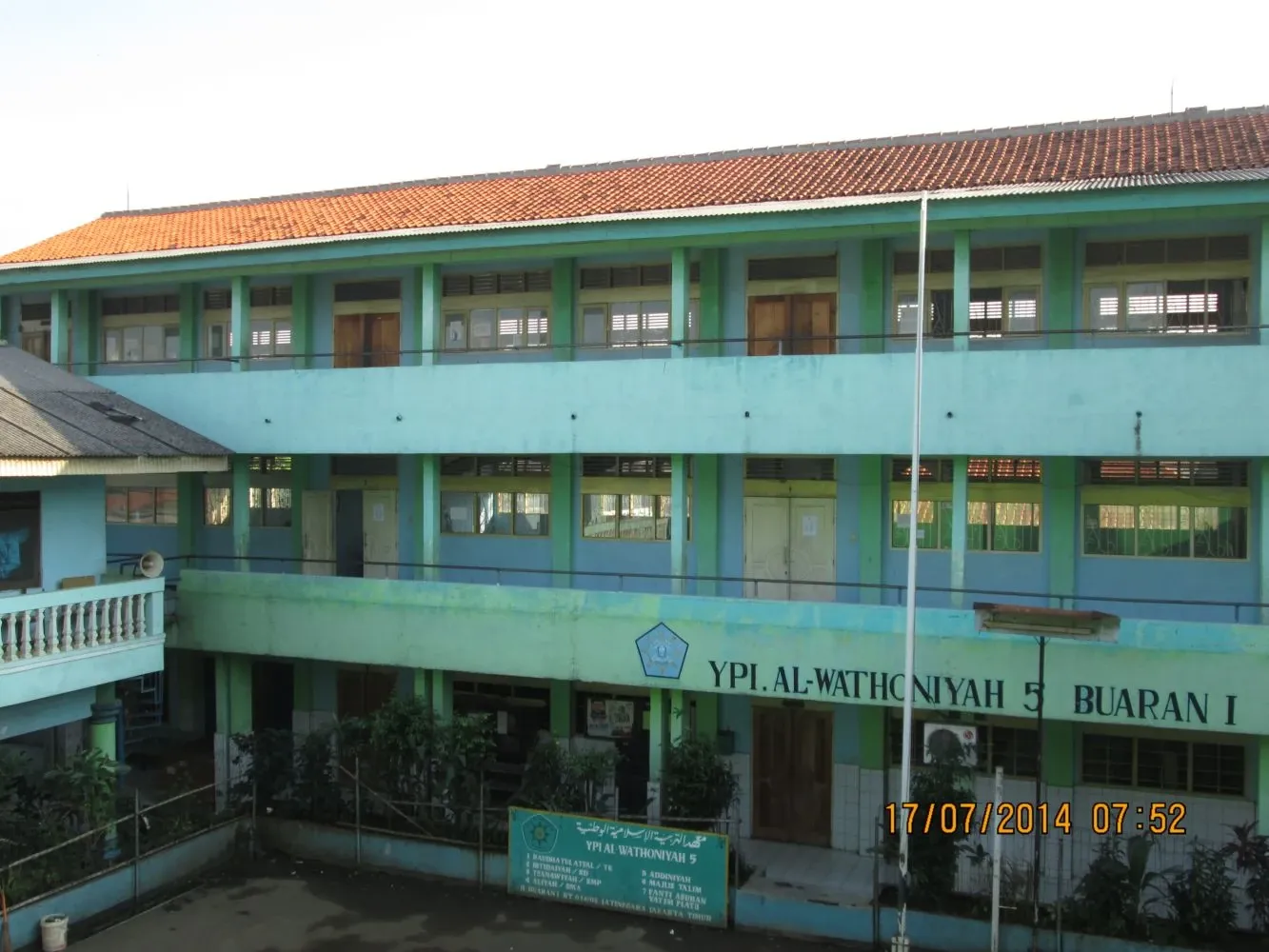 Gedung tiga lantai YPI Al Wathoniyah 5 Buaran I dengan dinding hijau toska dan atap genteng
